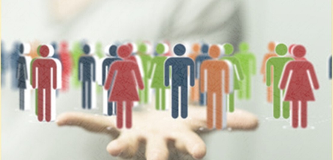 viele bunte diverse Männchen auf einer Hand. Das Bild hat verschwommenen hellgrauen Hintergrund.