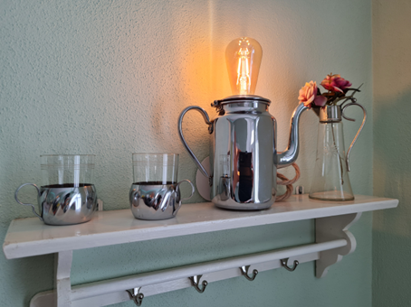 Kreative Wandlampe aus einer umgebauten Metallkanne.