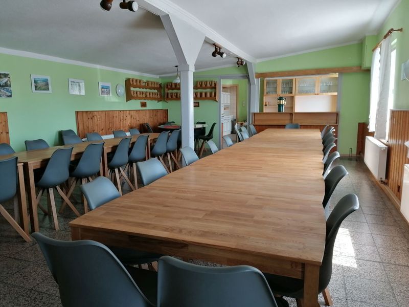 Heller Speisesaal mit langen Holztischen - dafür wurden neue Stühle und Tische angeschafft.