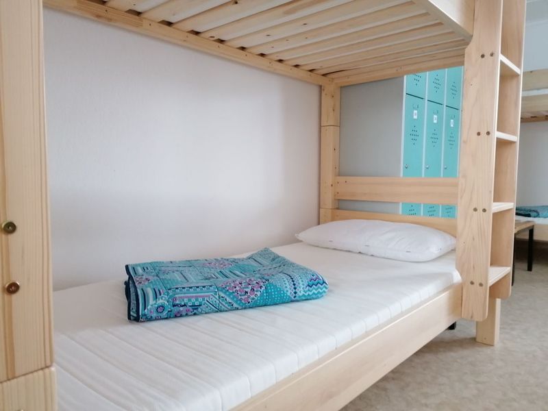 Helles Etagenbett aus Holz mit blauer Decke im Tennis-Bungalow