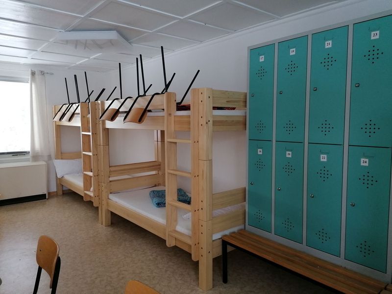 Schlafsaal mit Holz-Etagenbetten und Spinden im Tennis-Bungalow