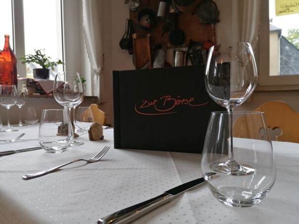Gäste erwartet ein stilvolles Ambiente Gedeckter Tisch im Restaurant „Zur Börse“ mit Gläsern und Speisekarte. (Link öffnet Bild vergrößert in einem Popupfenster)