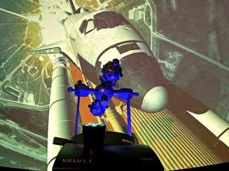 Moderner Sternenprojektor im Planetarium vor einer Kuppelprojektion eines Space Shuttles beim Start.